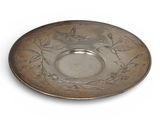 silver plate with a design of birds and flowers on it