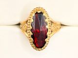 an image of a gold ring with a red stone in it