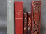 trois livres sont empilés sur une table