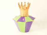 a purple and green vase with a gold crown on top