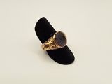 an image of a gold ring with a purple stone on it