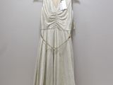 a white dress hanging on a hanger next to a white wall