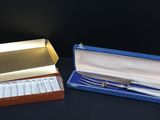 pair of silver plated spoons in a blue box on a black surface