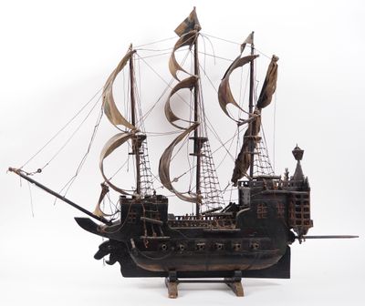 a wooden model of a pirate ship on a white surface