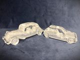 two clear plastic cars sitting side by side on a blue background