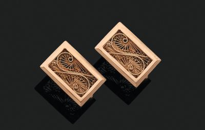 une paire de boucles d'oreilles en or aux motifs raffinés sur fond noir