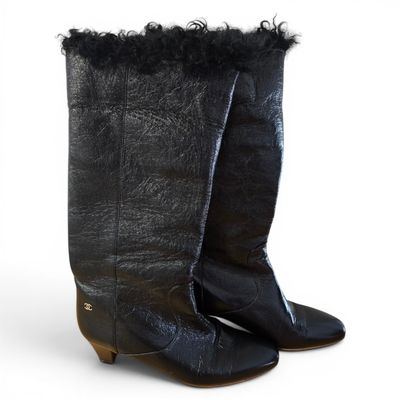 pair of black leather boots with fur on the soles