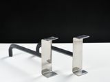 pair of metal bookends on a white surface against a black background