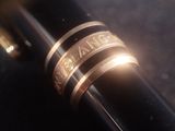 a close up of a pen with a ring on top of it