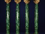 un ensemble de quatre colonnes en marbre vert ornées de détails dorés