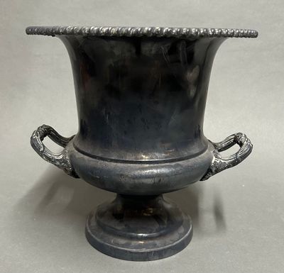 a large metal vase with a handle on it