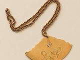 Gros plan sur un collier en or orné d'un oiseau