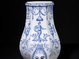 blue and white vase on stand on a black background