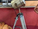 une lampe posée sur un trépied à côté d'un chapeau