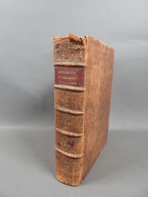 an old book sitting on top of a table next to a gray background