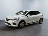 Une voiture blanche est garée dans une pièce au sol noir.