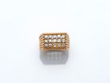 une bague en or et diamants posée sur une surface blanche