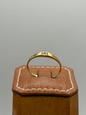 une bague en or posée sur un coffret en cuir marron
