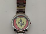 montre en argent avec un logo Ferrari rouge et jaune sur le cadran