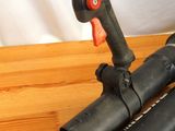 two black pipes and a red handle on a wooden table