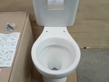 a white toilet sitting next to a cardboard box on the floor
