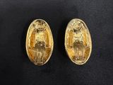 a pair of gold earrings with an image of a woman and a man