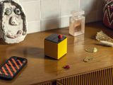 un téléphone portable posé sur une table en bois à côté d'un vase