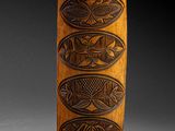 an image of a tall wooden object with carvings on it