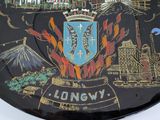 a black plate with a picture of a city on it