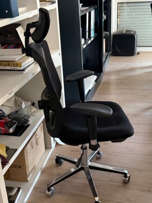 une chaise de bureau noire placée devant une bibliothèque
