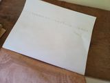 a piece of paper sitting on top of a cutting board next to a knife