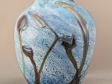a blue vase with a flower on it on a table
