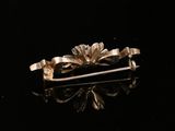 gold plated flower broocher on black surface with reflection