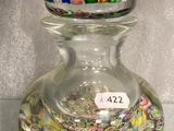 un bocal en verre muni d'un couvercle en verre, posé sur une table en verre