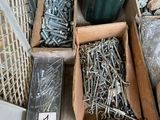 many different types of screws in boxes on the floor