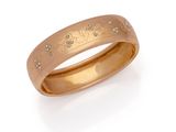 gros plan d'une bague en or avec des diamants sur fond blanc