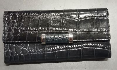 portefeuille en cuir de crocodile avec un fermoir métallique sur fond blanc