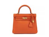 a small orange leather handbag on a white background