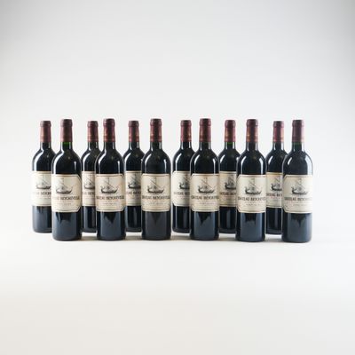 six bottles of red wine lined up in a row on a white surface