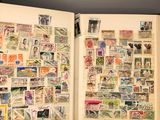 an open book with stamps on it sitting on top of a table