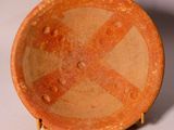 a large orange bowl sitting on top of a white table