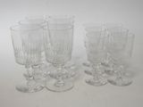 six clear wine glasses sitting on top of a white table