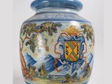 a blue and white vase with a coat of arms on it