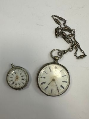 deux montres de poche posées l'une à côté de l'autre sur une table