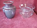 two glass vases sitting on a pink cloth