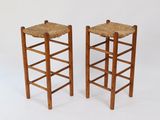 une paire de tabourets en bois avec des assises tressées, sur fond blanc