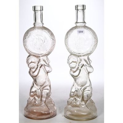 two clear glass bottles with a monkey holding a coin on top of them