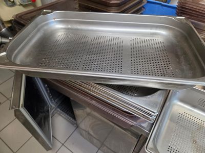 Plusieurs plateaux de nourriture sont empilés les uns sur les autres dans une cuisine