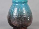 un vase bleu et noir posé sur une table