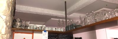 de nombreux verres sur les étagères au-dessus du comptoir